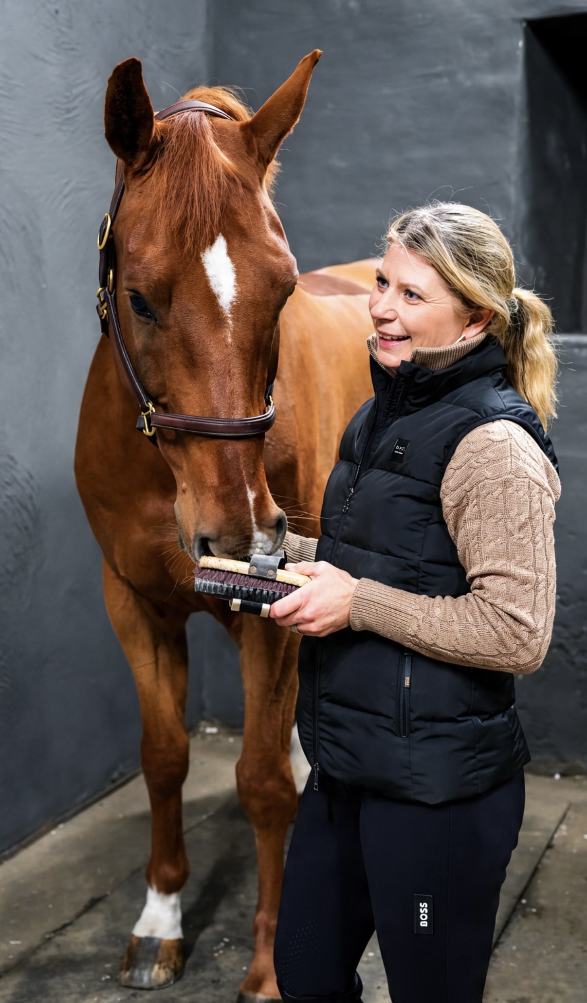 Linda Heed grooming her horse in the stable